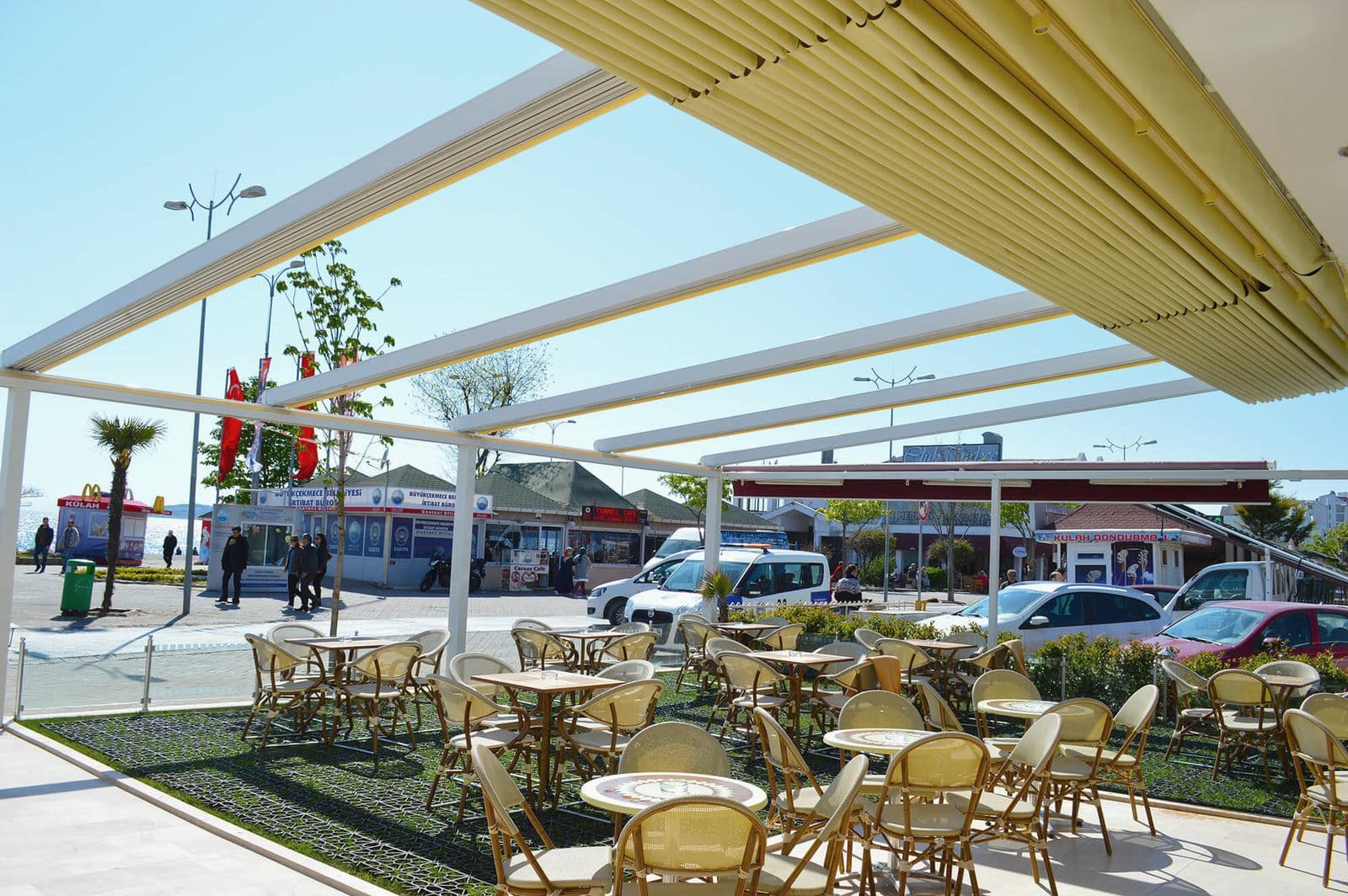 Kafe terasında beyaz boyalı alüminyum pergole karkası